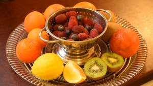 Fruit salad ingredients on a glass plate and colander