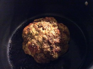 Baked whole cauliflower, topped with melted cheese