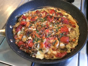 Egg and vegetable breakfast tortilla in pan